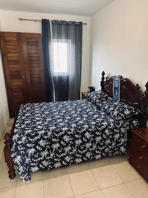 a bedroom with a bed with a blue and white blanket at Condominio Finaçon praia ilha santiago in Prainha