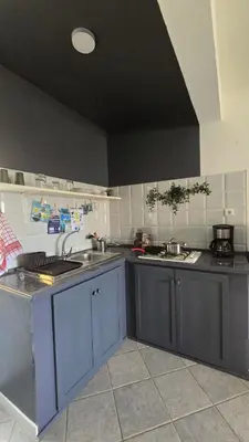 a kitchen with blue cabinets and a black ceiling at Celina's Cozy Studio & Beach Life in One in Santa Maria