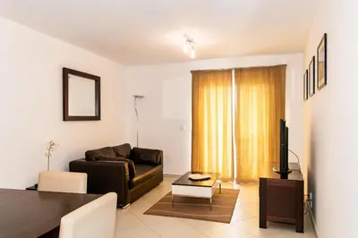 a living room with a couch and a television at HostySpot - Melia Dunas in Santa Maria
