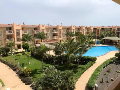 an aerial view of a resort with a swimming pool and palm trees at Tropical Mediterraneo in Santa Maria