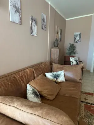 a living room with a brown couch with pillows at Tropical Mediterraneo in Santa Maria