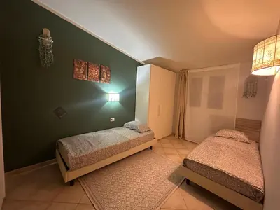 two beds in a bedroom with green walls at Tropical Mediterraneo in Santa Maria