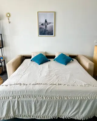 a bed with two blue pillows on top of it at Surfing Ocean View Appartment in Sal Rei