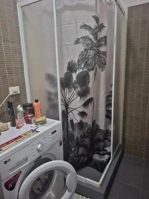 a bathroom with a shower curtain with a washing machine at Surfing Ocean View Appartment in Sal Rei