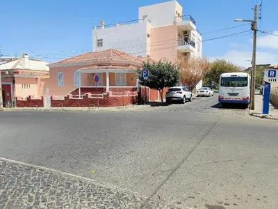 a bus is parked in front of a pink house at Vivenda Paraíso, Charming house on the Plateau in Praia