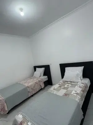 two beds in a room with white walls at Appartement Praia Sao Felipe in Praia