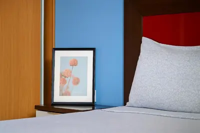 a picture of a flower in a frame next to a bed at Cantinho dos Dias in Espargos