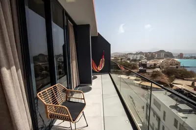 a chair sitting on the balcony of a building at Suncent apartment in Mindelo