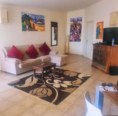 a living room with a couch and a table at Tropical Resort Pool View - Apartment in Santa Maria