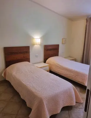 a hotel room with two beds with white sheets at Tropical Resort Pool View - Apartment in Santa Maria