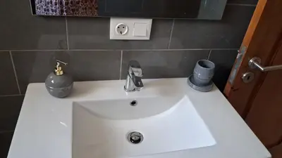 a white sink in a bathroom with a mirror at Miguel House in Santa Maria