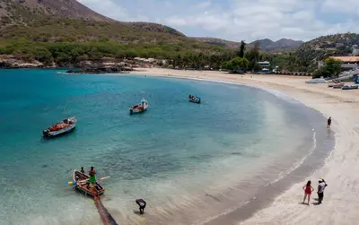 people standing on a beach with boats in the water at Casa Ida 1 Tarrafal, Santiago, Cabo Verde in Tarrafal