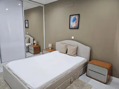 a bedroom with a large white bed and a mirror at T3 Duplex - Palmarejo Grande in Praia