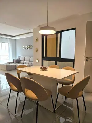 a dining table and chairs in a living room at T3 Duplex - Palmarejo Grande in Praia