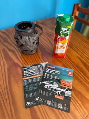 a table with a carton of orange juice and a car magazine at Murdeira V17 RC by RPG Group in Beirona