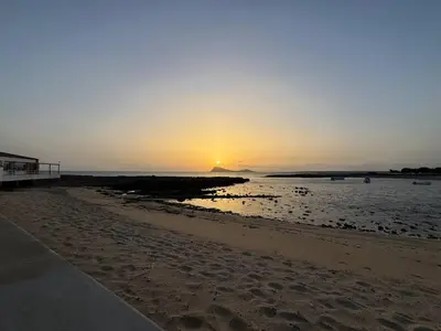 a sunset on a beach with the sun setting at Murdeira V17 RC by RPG Group in Beirona