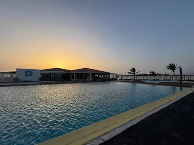 a large swimming pool with a sunset in the background at Murdeira V31 G by RPG Group in Beirona