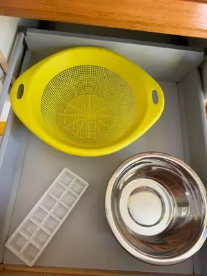 a yellow strainer sitting on top of a kitchen counter at Murdeira V 31 H by RPG Group in Beirona