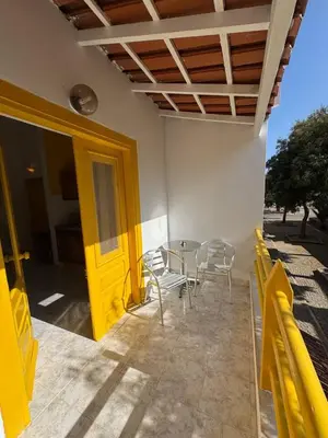 a yellow door on a patio with a table and chairs at Murdeira V 31 H by RPG Group in Beirona