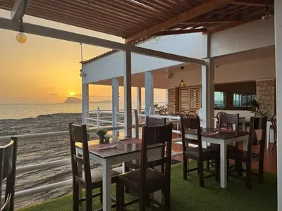 a dining room with a table and chairs and the ocean at Murdeira V 31 H by RPG Group in Beirona