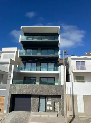 a tall white building with a lot of windows at Boa Vista Apartment in Prainha