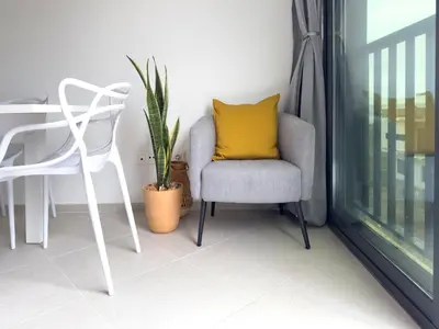 a chair with a yellow pillow sitting next to a window at Cozy apt amazing seaview - 2 min from beach - LCGR in Tarrafal