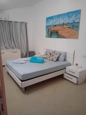 a bed in a bedroom with a painting on the wall at Casa Mendonça in Santa Maria