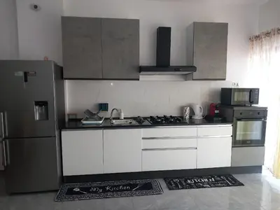 a kitchen with white cabinets and a stainless steel refrigerator at Sal Rei ,Boavista Magic Apartment - in Sal Rei