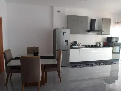 a kitchen with a table and chairs and a refrigerator at Sal Rei ,Boavista Magic Apartment - in Sal Rei