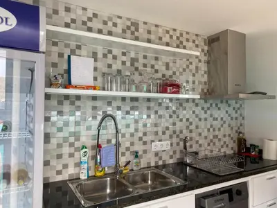 a kitchen with a sink and a tiled wall at Ponta do Sol 