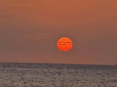 an orange sun in the sky over the ocean at T0 Bounty in Santa Maria