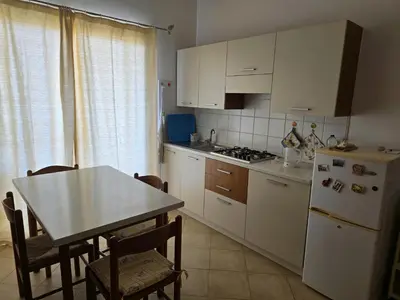 a kitchen with a table and a white refrigerator at T0 Bounty in Santa Maria