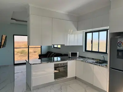a kitchen with white cabinets and a stove top oven at Ponta de mar in Praia