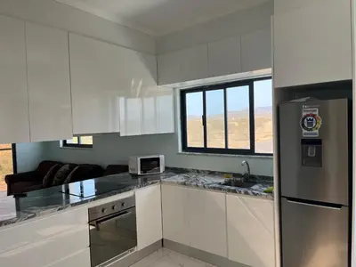 a kitchen with white cabinets and a counter top at Ponta de mar in Praia