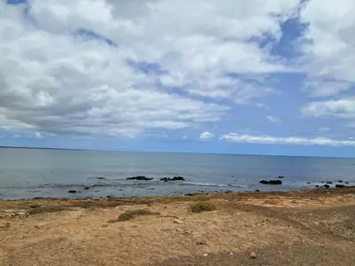 a beach with rocks in the water under a cloudy sky at Vivenda Mia in Beirona
