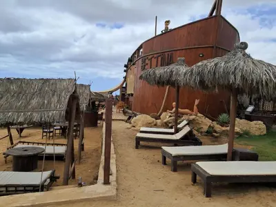 a group of tables and umbrellas next to a ship at Vivenda Mia in Beirona