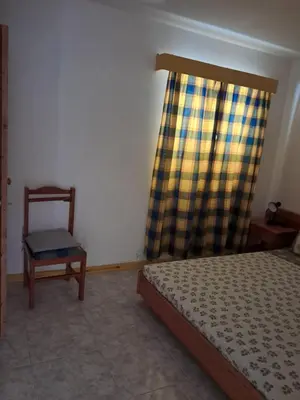 a bedroom with a bed and a chair and a window at Vivenda Mia in Beirona