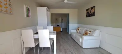 a living room with a white couch and a table at Bungalow Praia de Chaves Sol & Mar in Cabeçadas