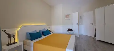 a bedroom with a yellow bed with blue pillows at Bungalow Praia de Chaves Sol & Mar in Cabeçadas