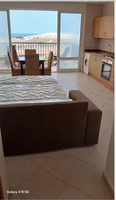 a living room with a table and chairs and a kitchen at Pandora Ocena View II in Sal Rei