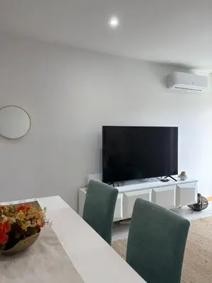 a living room with a table with chairs and a television at Santa Maria Residence - Central T2 in Santa Maria