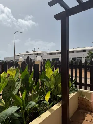 a cross in front of a fence with plants at T-2 Santa Maria in Santa Maria