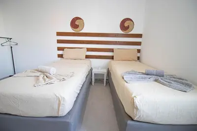 two beds in a room with towels on them at Modern Gateway in Santa Maria