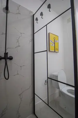 a bathroom with a toilet and a glass shower door at Modern Gateway in Santa Maria
