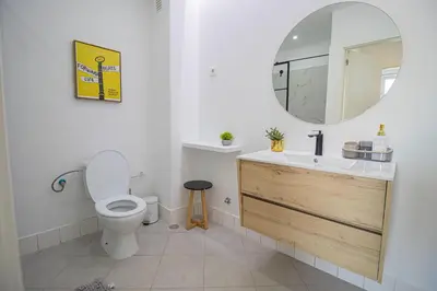 a bathroom with a toilet and a sink and a mirror at Modern Gateway in Santa Maria