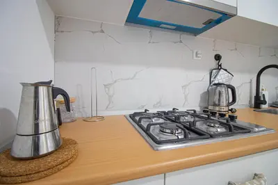 a kitchen counter with a stove top with a tea kettle at Modern Gateway in Santa Maria