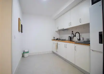 a white kitchen with white cabinets and a sink at Modern Gateway in Santa Maria