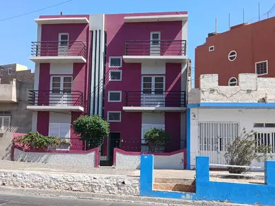 a pink building with balconies on a city street at Mar&Cruz in Mindelo