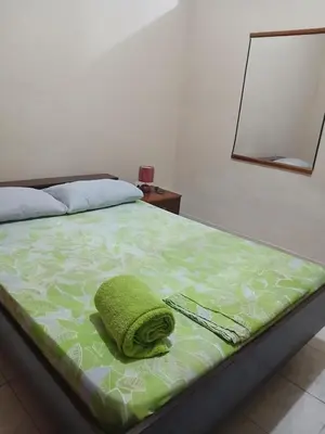 a bed with a green pillow on top of it at Mar&Cruz in Mindelo