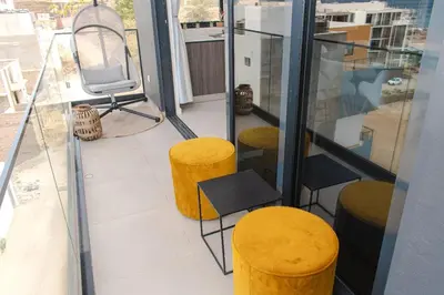 a balcony with two yellow stools and a chair at Santa Ocean View in Mindelo